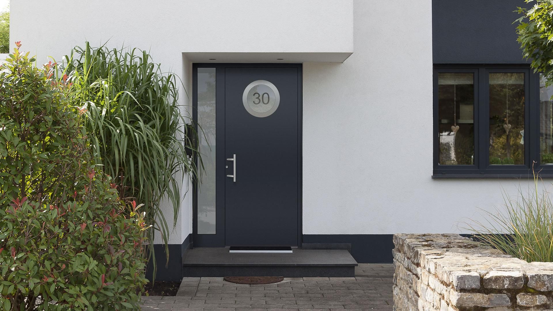 Moderne anthrazitfarbene Aluminium-Haustür an einem Einfamilienhaus